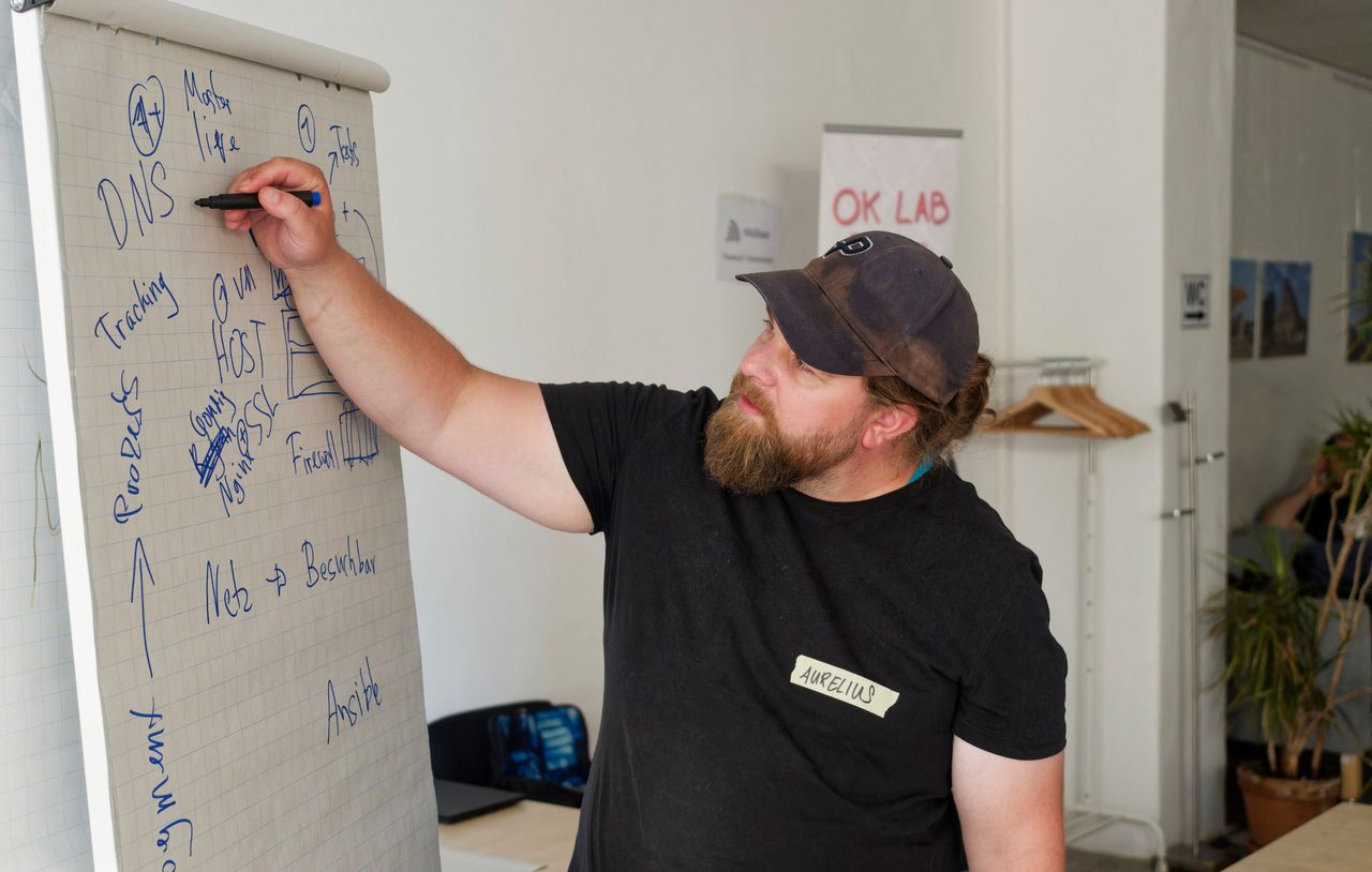 Ein Teilnehmer erklärt technische Zusammenhänge an einem Flipchart.